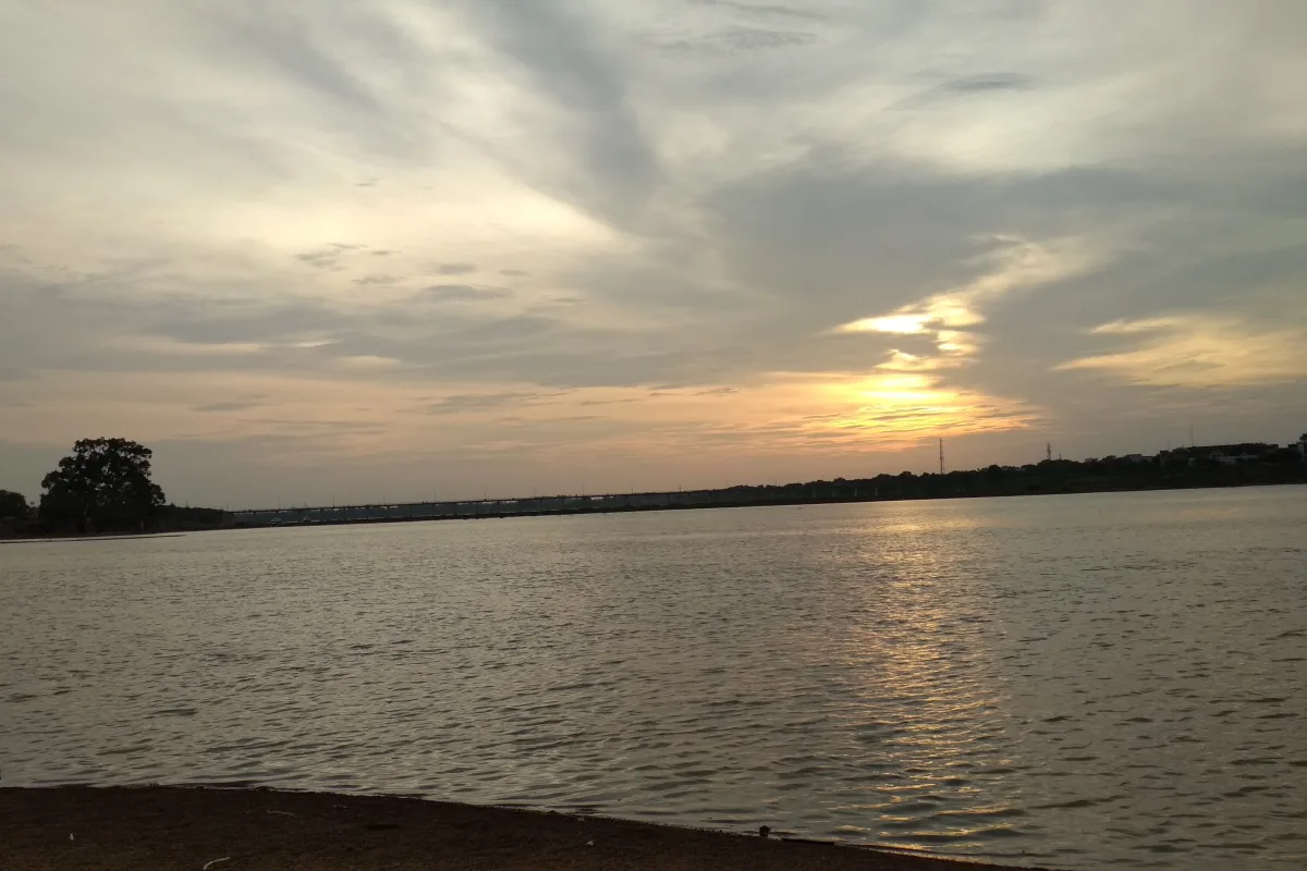 The wide Mahanadi river at Rajim at sunset under a cloudy sky