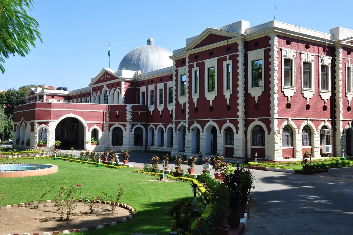 The red and cream colonial-style Jharkhand High Court building in Ranchi with a dome and a lawn in front