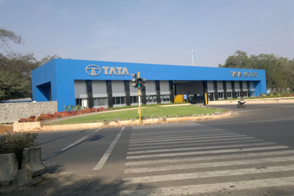 The blue Tata Motors office and plant building in Pune seen across a road junction